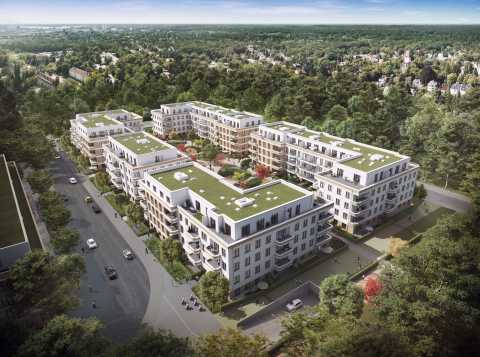 Neue, moderne Wohnhäuser mit begrünten Dächern inmitten einer grünen Umgebung.