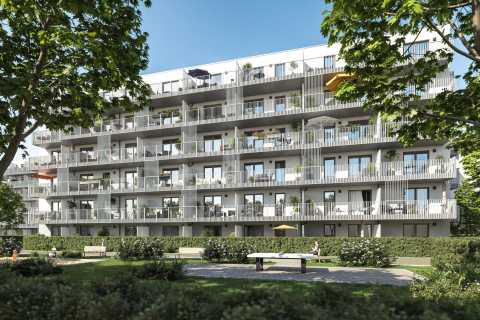 Modernes Wohnhaus mit Balkonen, davor eine Grünanlage mit Bänken und Tischtennis.