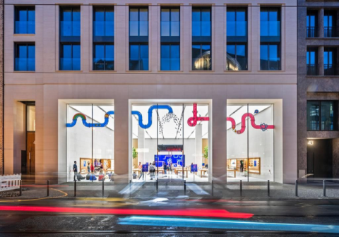 Großes, beleuchtetes Ladengeschäft mit Glasfront und bunten Röhren an der Decke.