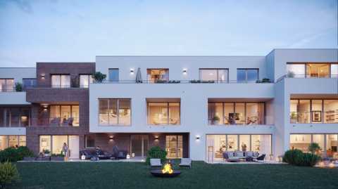 Modernes Mehrfamilienhaus mit großen Fenstern, Balkonen und Garten bei Dämmerung.