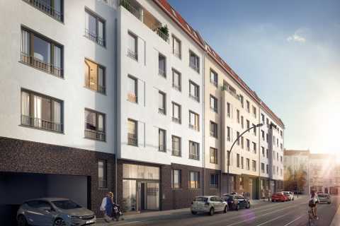 Mehrstöckiges Wohnhaus an Straße, Autos parken, Menschen gehen und fahren Rad.