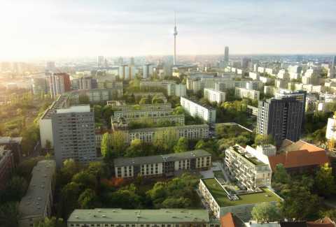 Stadtansicht mit vielen Häusern, viel Grün und dem Berliner Fernsehturm im Hintergrund.
