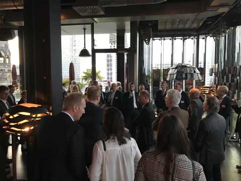 Gruppe von Menschen bei einer Abendveranstaltung in einem modernen Innenraum.