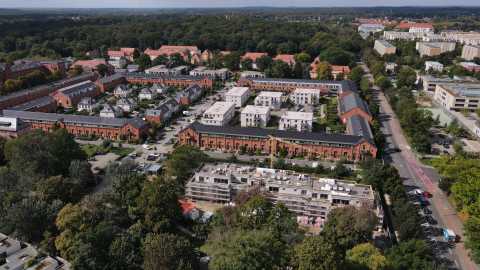 Luftbild eines Wohnviertels mit roten Backsteinhäusern und moderner Neubau.
