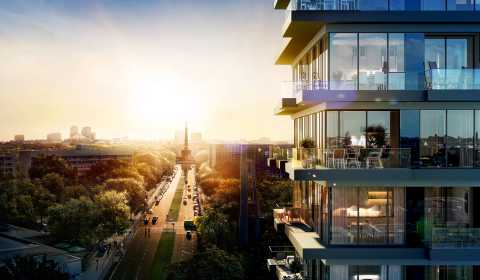 Moderner Wohnblock mit Glasfassade, Sonnenuntergang und Straße mit Bäumen.