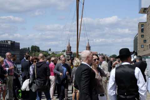 Viele Menschen stehen draußen am Wasser mit Blick auf die Oberbaumbrücke.