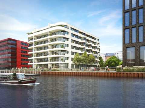 Modernes weißes Wohngebäude am Wasser, Menschen und Boot im Vordergrund.