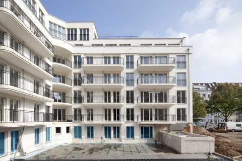 Neubau eines modernen Mehrfamilienhauses mit vielen Balkonen und Glasfronten.