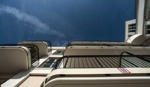 Balkone eines modernen Gebäudes vor blauem Himmel aus der Froschperspektive.