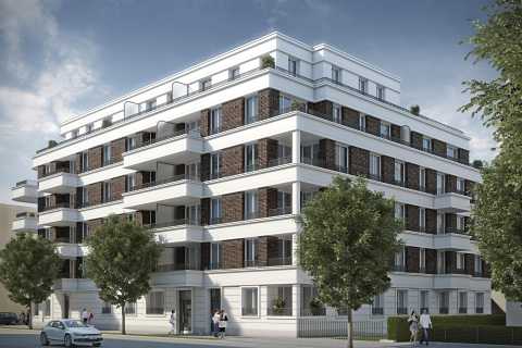 Modernes Mehrfamilienhaus mit Balkonen und Bäumen davor bei Tageslicht.