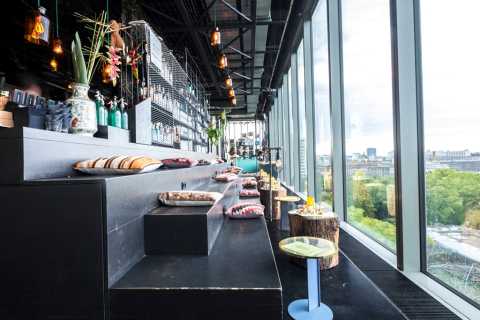 Modernes Café mit Ausblick, Sitzkissen auf Podesten, große Fenster, helle Atmosphäre.