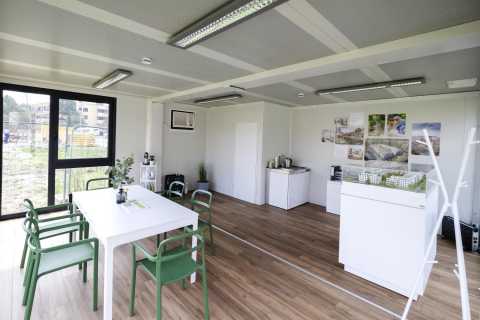 Moderner Besprechungsraum mit weißen Möbeln und Architekturmodellen.