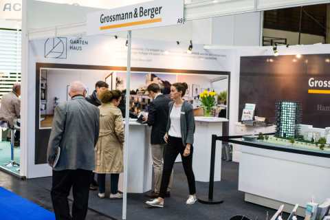 Messestand von Grossmann & Berger mit Besuchern und Architekturmodell.